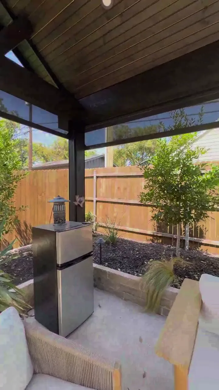 Fort Worth covered patio with a lounge sofa as a motorized shade lowers over the opening
